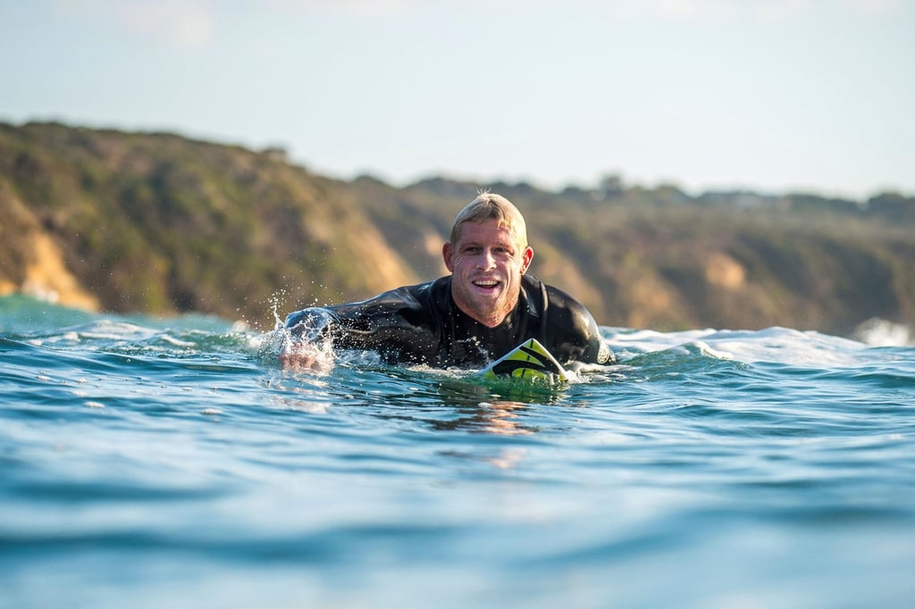 A man riding a wave on a surf board on a body of water